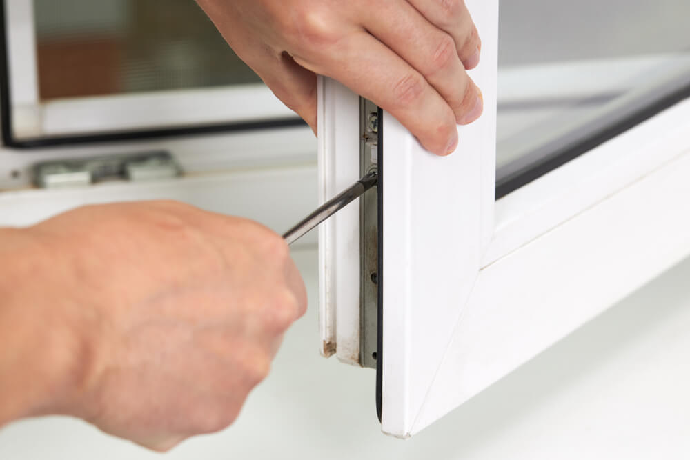 Image of two hands adjusting a uPVC window